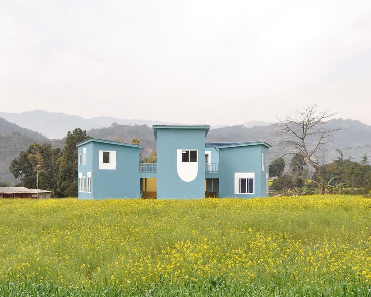 SOSD blue campus rising above mustard fields in Bodgaun